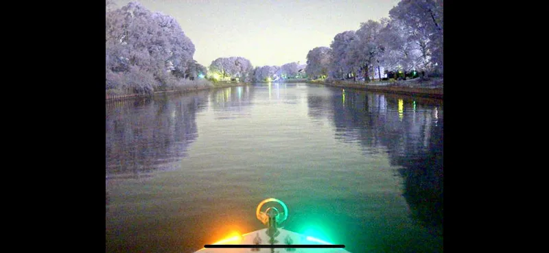  Yacht Photos Pics 2004 Contender 31 Fish Around boat navigating a serene, tree-lined waterway at night.