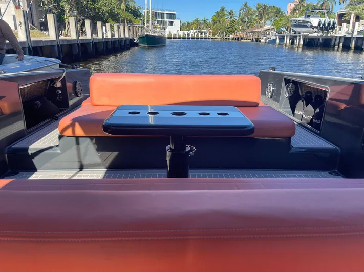  Yacht Photos Pics 2013 VanDutch 40 Open Bow with orange seating and table, docked by a scenic waterfront.