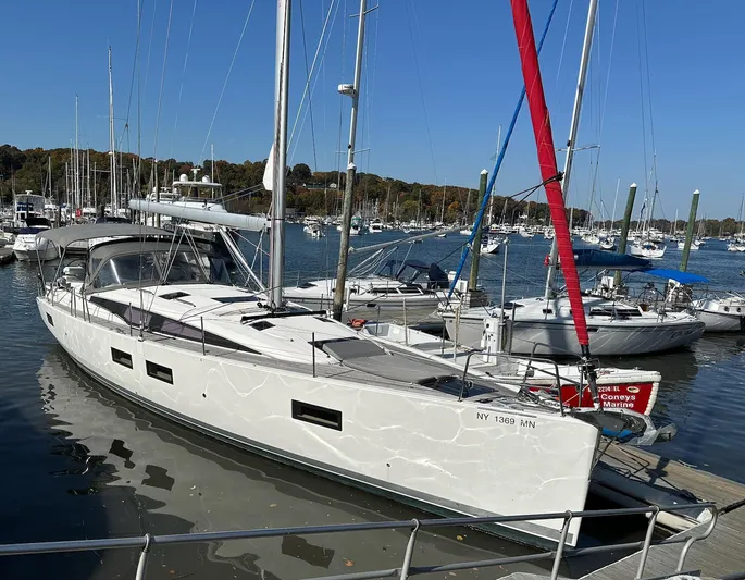  Yacht Photos Pics 2018 Jeanneau 51 sailboat docked in a marina under clear blue skies.