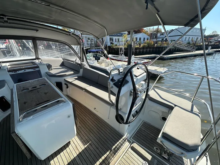  Yacht Photos Pics 2018 Jeanneau 51 yacht cockpit with steering wheel, seating, and waterfront view.