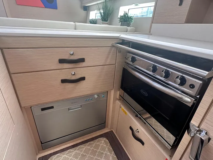  Yacht Photos Pics Modern kitchen in 2018 Jeanneau 51 yacht with oven, dishwasher, and storage drawers.