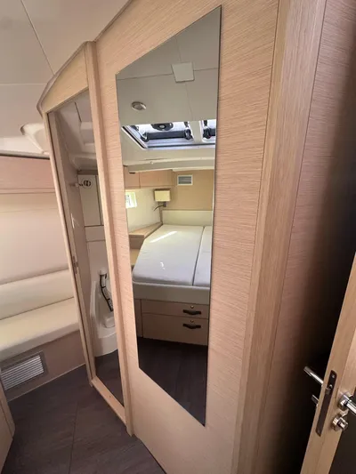  Yacht Photos Pics Interior of 2018 Jeanneau 51 yacht with modern wood finish and mirror.