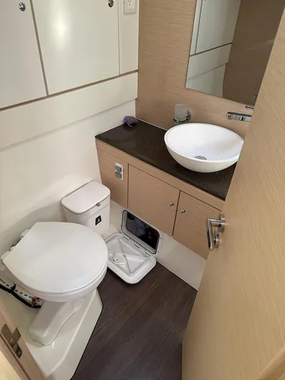  Yacht Photos Pics Modern bathroom in 2018 Jeanneau 51 yacht with sink, toilet, and storage.