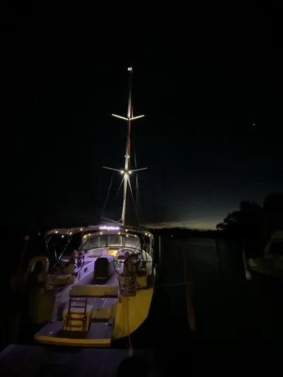  Yacht Photos Pics 2018 Jeanneau 51 sailboat illuminated at night, docked with a dark sky backdrop.