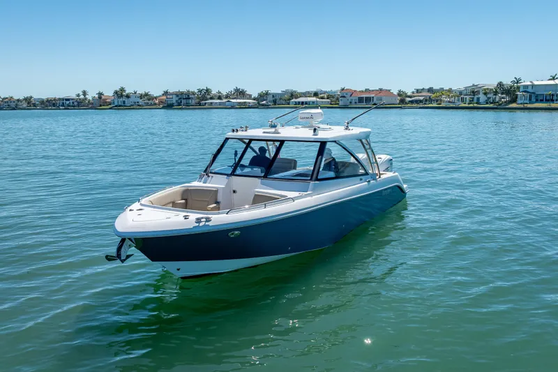 Kashmir Yacht Photos Pics 2019 Everglades 340 Dual Console boat on calm water, coastal homes in background.