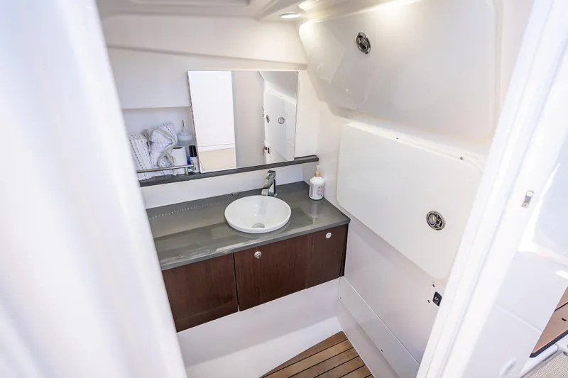 Kashmir Yacht Photos Pics 2019 Everglades 340 Dual Console boat bathroom with sink, mirror, and storage cabinets.