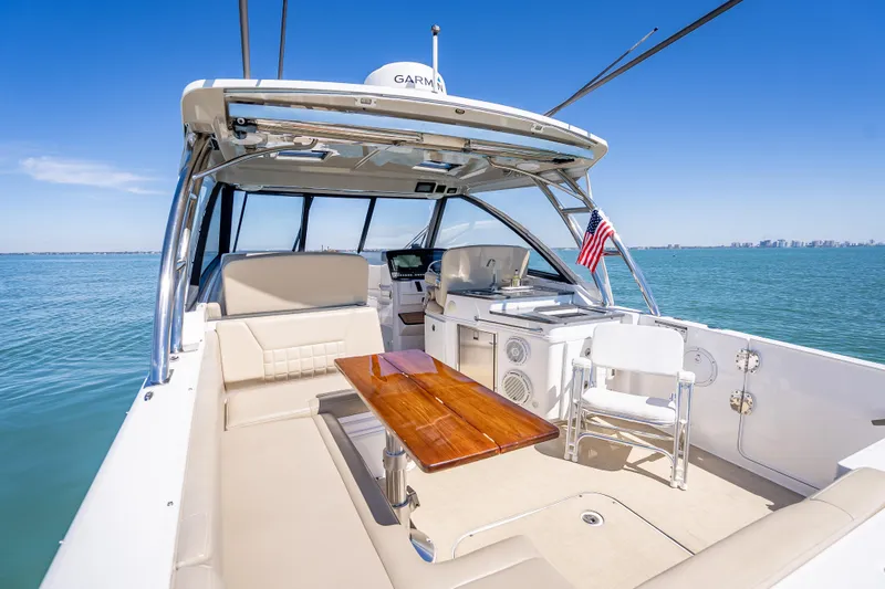 Kashmir Yacht Photos Pics 2019 Everglades 340 Dual Console boat interior with seating, table, and ocean view.