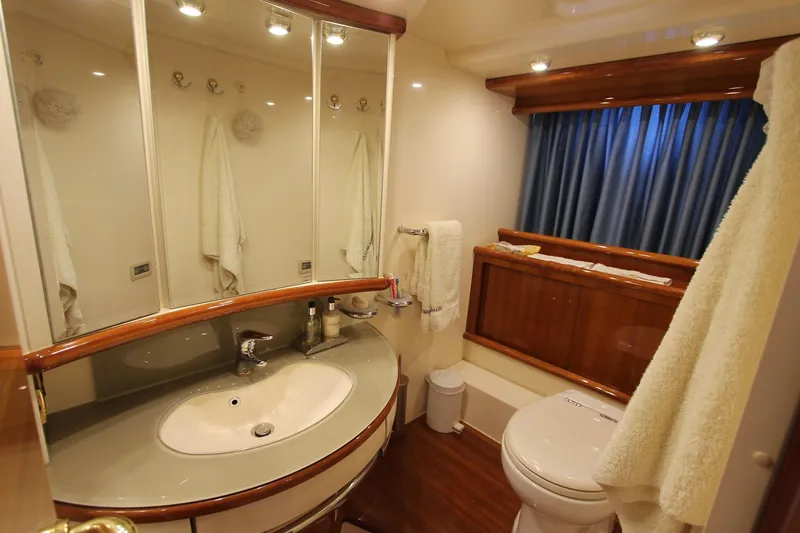 Sevrik Yacht Photos Pics Luxurious bathroom in a 2004 Azimut 62 yacht with elegant fixtures and wood accents.
