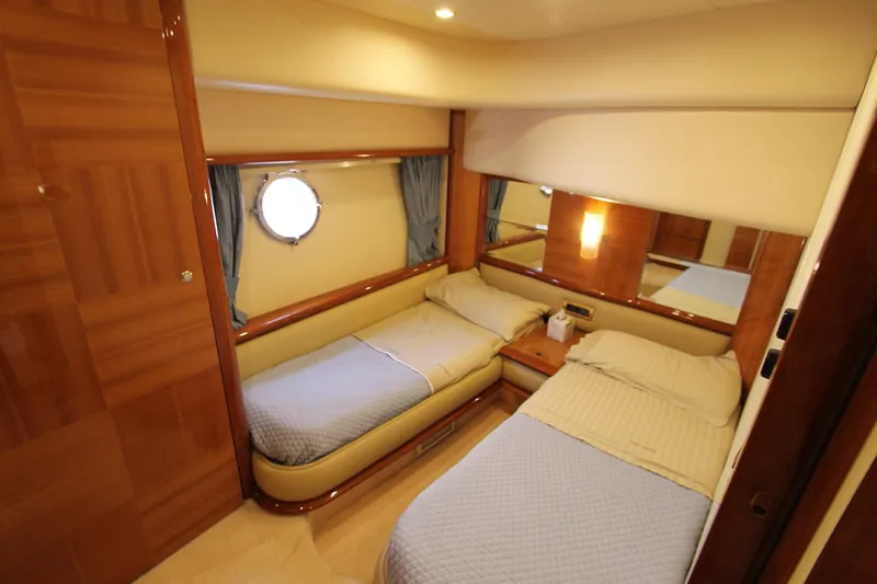 Sevrik Yacht Photos Pics Luxurious 2004 Azimut 62 yacht cabin with twin beds and elegant wood finishes.
