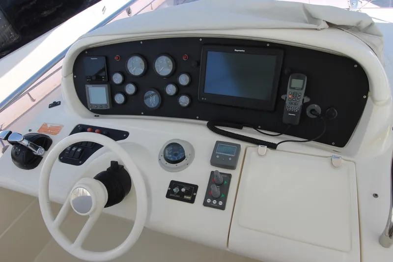 Sevrik Yacht Photos Pics Control panel of a 2004 Azimut 62 yacht with steering wheel and navigation instruments.