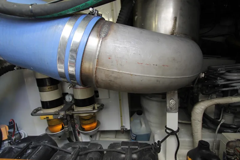 Sevrik Yacht Photos Pics Engine room of a 2004 Azimut 62 yacht, featuring pipes and mechanical components.