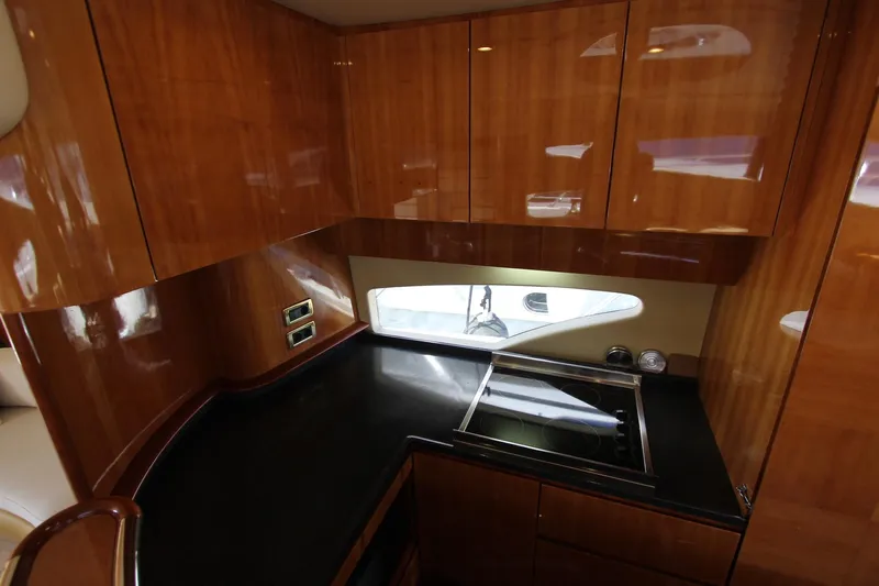 Sevrik Yacht Photos Pics Luxurious kitchen interior of 2004 Azimut 62 yacht with sleek wood cabinetry.