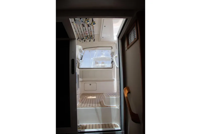Peixe Espada Yacht Photos Pics Interior view of 2016 Henriques 42 Express Hardtop boat with fishing rods and wooden flooring.