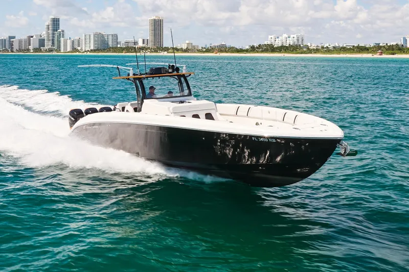  Yacht Photos Pics 2016 Midnight Express 43' Open boat cruising on clear blue water near a city skyline.