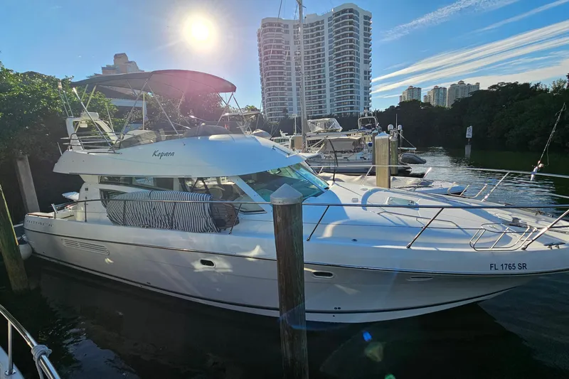 Kopara Yacht Photos Pics Prestige 46 yacht from 2005 docked in a marina with cityscape background.