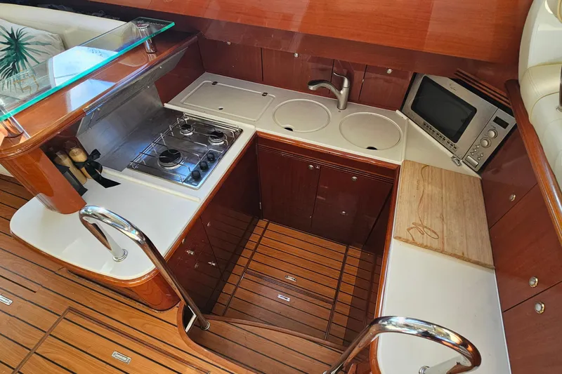 Kopara Yacht Photos Pics Luxurious 2005 Prestige 46 yacht kitchen with stove, sink, microwave, and wooden flooring.