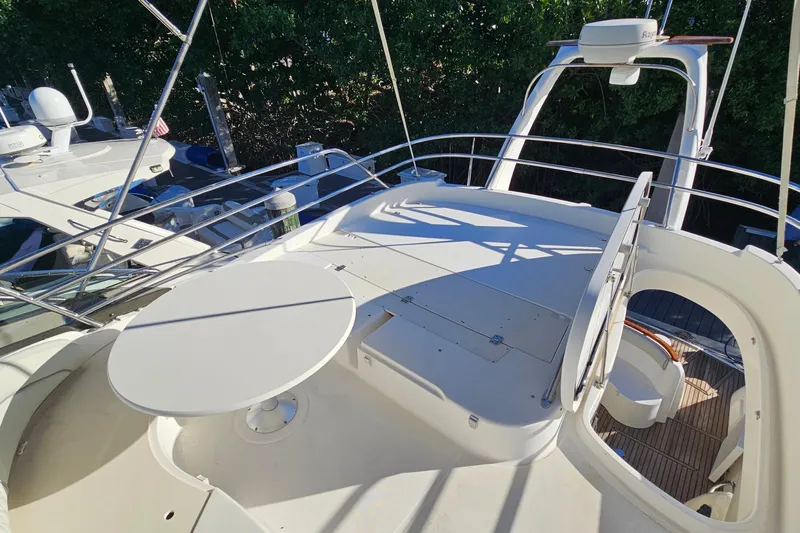 Kopara Yacht Photos Pics Flybridge of 2005 Prestige 46 yacht with seating and table, docked near other boats.