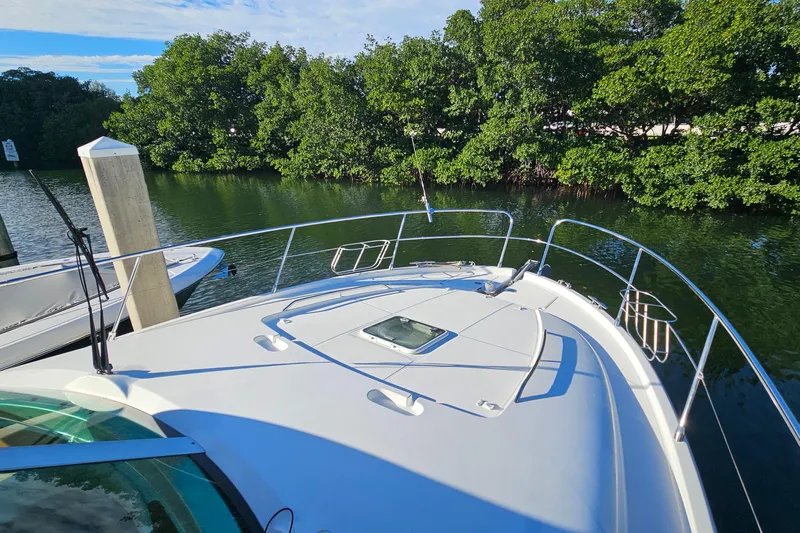 Kopara Yacht Photos Pics Prestige 46 yacht from 2005 docked near lush green trees.