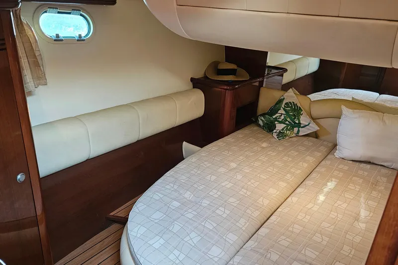 Kopara Yacht Photos Pics Luxurious cabin interior of a 2005 Prestige 46 yacht, featuring elegant bedding and wooden accents.
