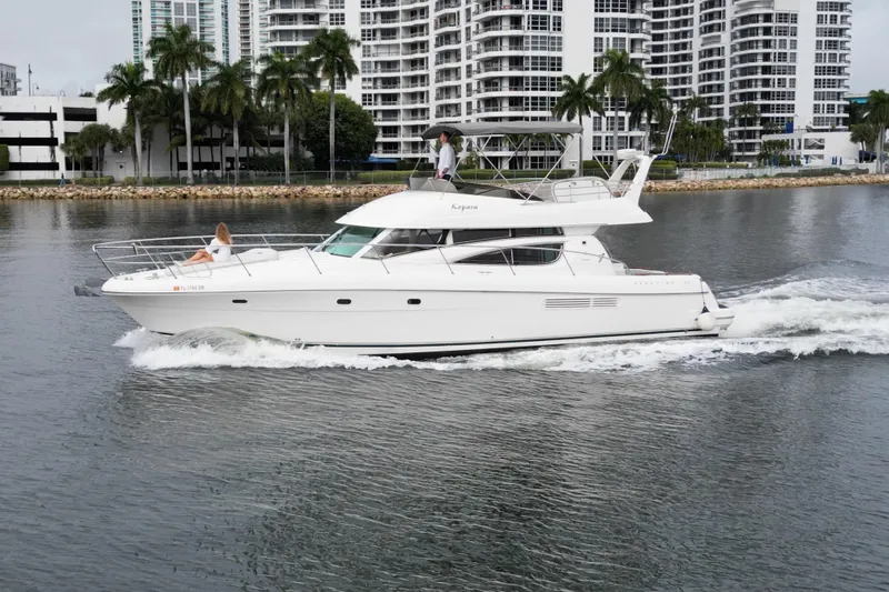 Kopara Yacht Photos Pics 2005 Prestige 46 yacht cruising near waterfront buildings and palm trees.