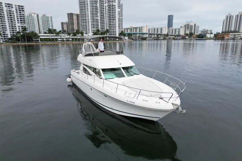 Kopara Yacht Photos Pics 2005 Prestige 46 yacht on calm water with city skyline backdrop.