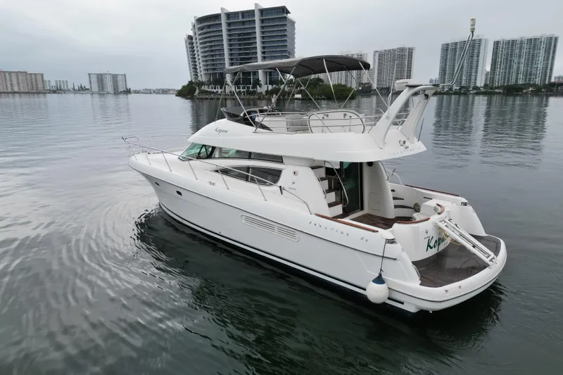 Kopara Yacht Photos Pics 2005 Prestige 46 yacht on calm water with city skyline backdrop.