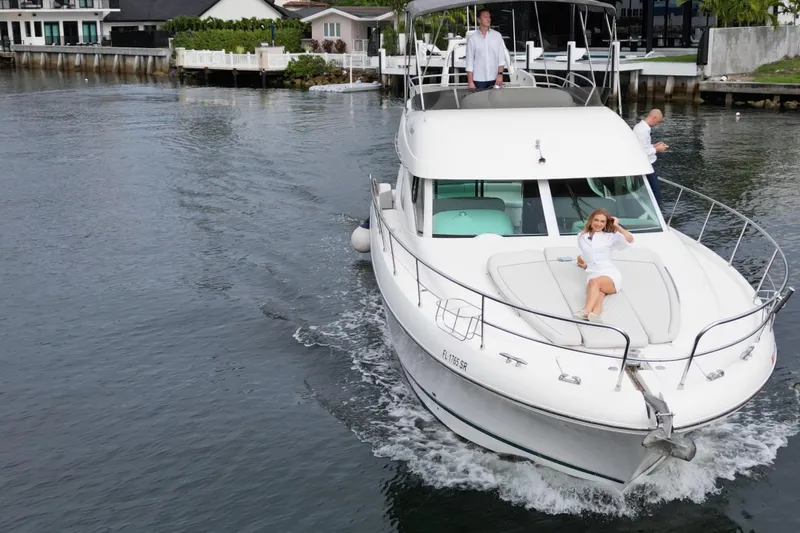 Kopara Yacht Photos Pics 2005 Prestige 46 yacht cruising with passengers on deck in a scenic waterfront setting.