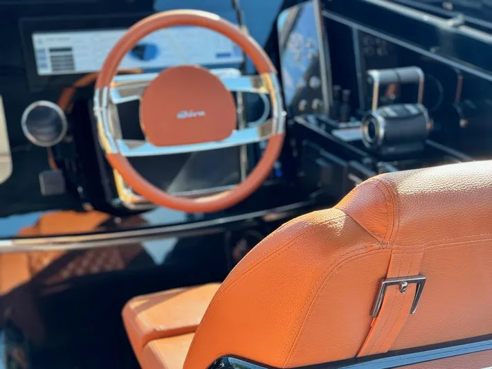 Grey Yacht Photos Pics Luxury interior of 2021 Riva 56 Rivale yacht with orange leather steering wheel and seat.