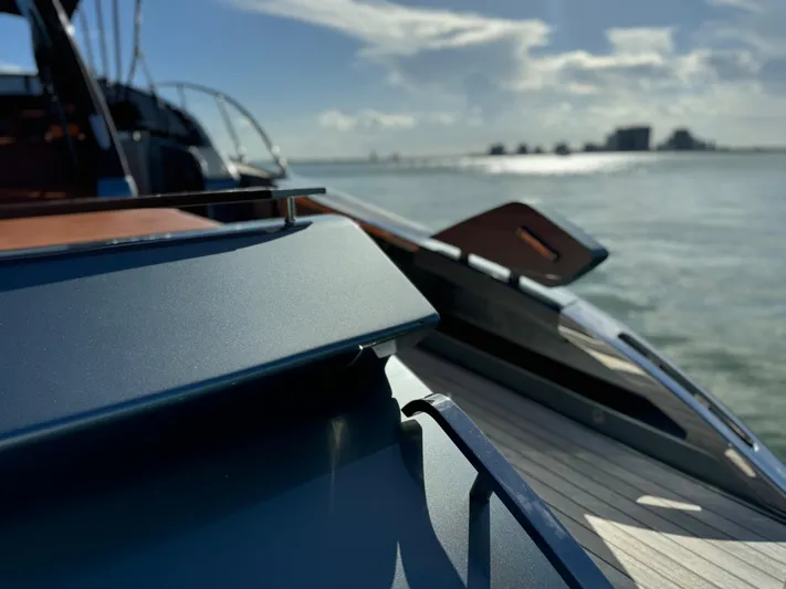 Grey Yacht Photos Pics 2021 Riva 56 Rivale yacht on calm waters under a sunny sky.