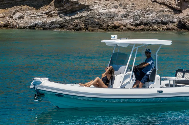  Yacht Photos Pics 2026 Highfield Sport 800 boat cruising on clear blue water near rocky shoreline.