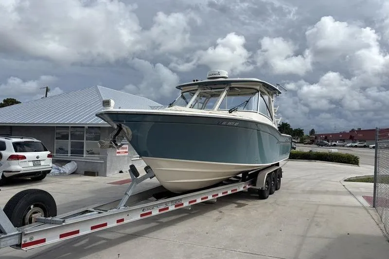  Yacht Photos Pics 2018 Grady-White Freedom 325 boat on trailer, parked outdoors under cloudy sky.