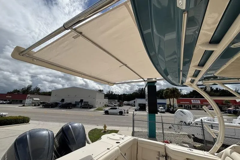  Yacht Photos Pics 2018 Grady-White Freedom 325 boat with dual engines and retractable canopy, parked near a dealership.