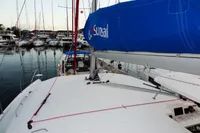 Leopard 40 catamaran docked in marina, featuring blue sail cover, surrounded by other boats.
