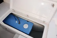 Open storage compartment on 2020 Leopard 40 boat with blue tank inside.