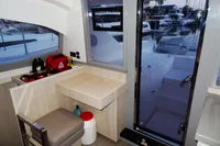 Interior of 2020 Leopard 40 catamaran with desk, chair, and marina view.