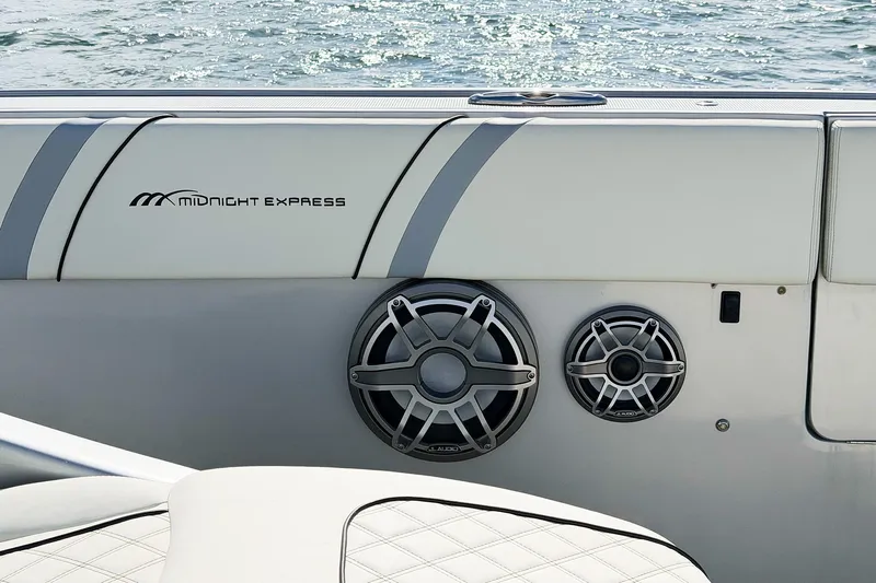 Yacht Photos Pics Midnight Express 43 Open boat interior with speakers and logo, on water background.