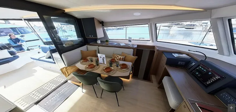 Good Wibe Yacht Photos Pics Luxurious interior of 2024 Nautitech 48 Open catamaran with dining area and panoramic windows.