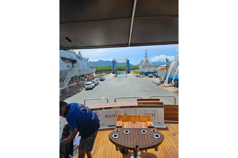 Megisti Spirit Yacht Photos Pics 2008 Westcoaster 70 Flybridge Cruiser docked at a busy shipyard with scenic mountain views.