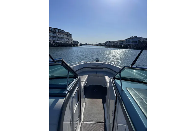  Yacht Photos Pics 2019 Formula 310 FX Bowrider cruising on a sunny waterfront with houses.