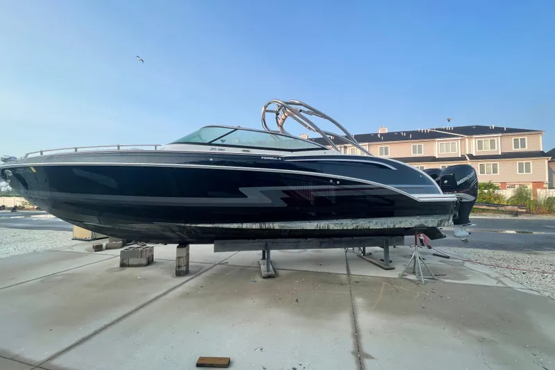  Yacht Photos Pics 2019 Formula 310 FX Bowrider boat on dry dock, sleek black design, residential background.
