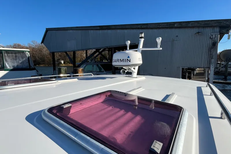 Galene Yacht Photos Pics 2010 Back Cove 33 Express Hardtop with Garmin radar, docked near a boathouse.