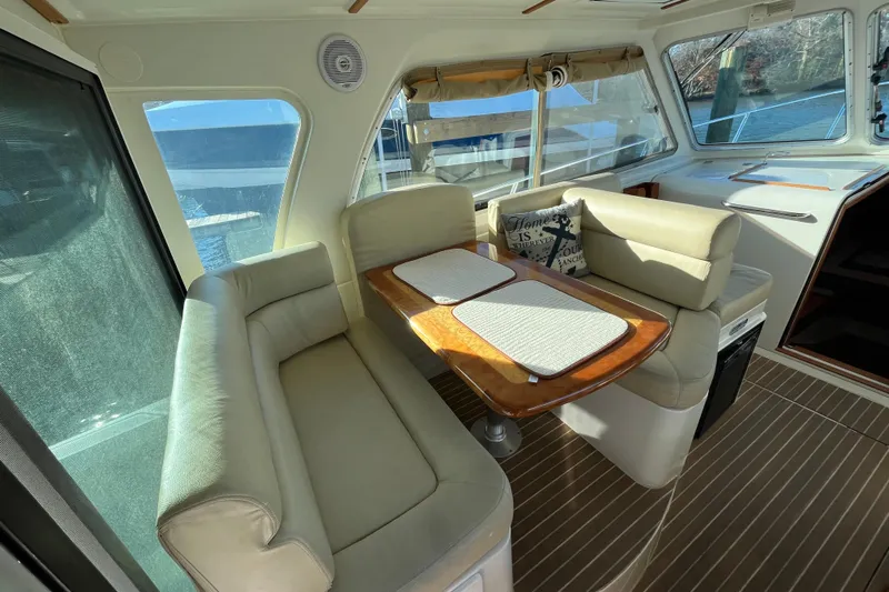 Galene Yacht Photos Pics 2010 Back Cove 33 Express Hardtop interior with beige seating and wooden table.