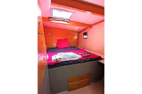Cozy cabin interior of 2015 Flash Cat 52S with bed, storage, and window.