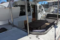 Outdoor seating area on a 2015 Flash Cat 52S yacht with table and cushions.