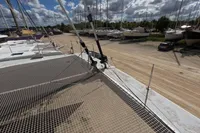Catamaran Flash Cat 52S (2015) on dry dock, surrounded by other boats under a cloudy sky.
