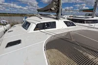 2015 Flash Cat 52S catamaran docked, featuring spacious deck and netting under a cloudy sky.
