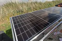 Solar panels on a 2015 Flash Cat 52S boat, near a grassy riverside.