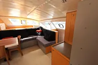 Interior of 2015 Flash Cat 52S yacht with cozy seating and wooden cabinetry.