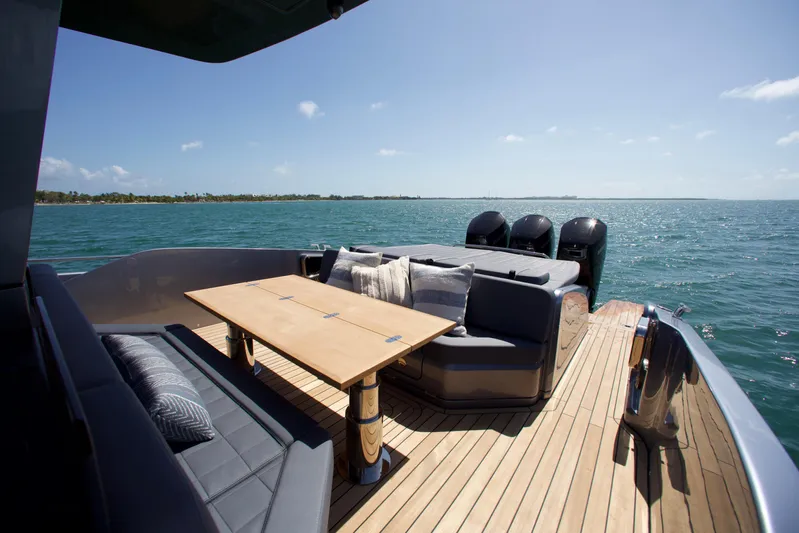  Yacht Photos Pics Luxurious 2022 SACS 47 Rebel yacht deck with seating and table, overlooking serene ocean waters.