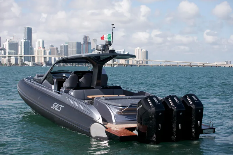  Yacht Photos Pics 2022 SACS 47 Rebel yacht cruising near city skyline, featuring triple outboard engines.